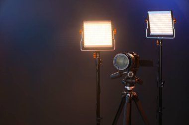Profesyonel ışıklandırma ekipmanı ve renkli arka planda kamera. Metin için boşluk