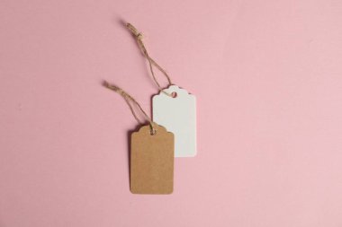 Pembe arka planda dizgileri olan boş etiketler, düz uzanma