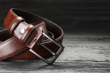 Tahta masada kahverengi bir deri kemer, yakın plan. Metin için boşluk