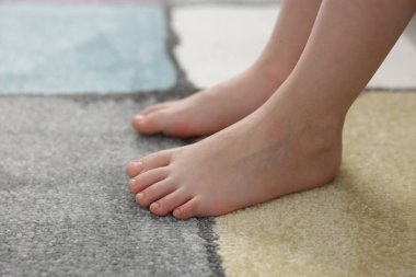 Evdeki yumuşak halıdaki kız, yakın plan.