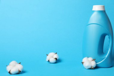 Açık mavi arkaplanda yumuşatıcı ve pamuk çiçekleri, metin için boşluk