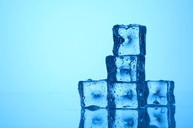 Açık mavi zemin üzerinde açık buz küpleri, yakın plan. Metin için boşluk