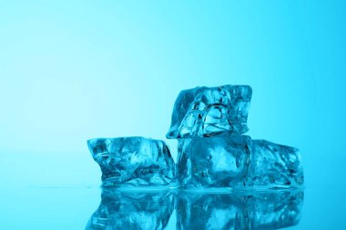 Açık mavi zemin üzerinde açık buz küpleri, yakın plan. Metin için boşluk