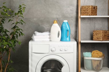 İçerideki çamaşır makinesinde yumuşatıcı ve havlu şişeleri.