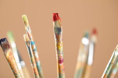 Açık kahverengi arkaplanda kirli fırçalar, yakın plan.