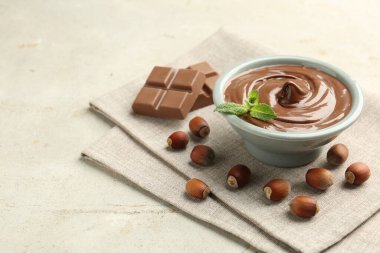 Lezzetli çikolata, parçalar, nane ve fındıklar ışık masasında, yakın plan. Metin için boşluk
