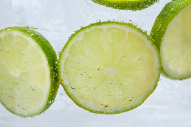 Kola suyunu limon dilimleri ve beyaz arka planda buzla tazeliyorum. Yakın plan.