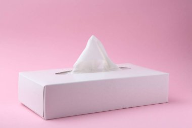Pembe arka planda kağıt mendilli kutu, yakın plan.