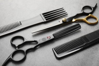 Gri masadaki farklı kuaför aletleri, yakın plan.