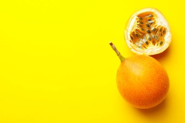 Sarı arka planda olgun çarkıfelek meyveleri, düz yatış. Metin için boşluk