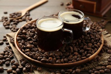 Aromatik kahve fincanlarda ve fasulyeler ahşap masada, yakın plan.