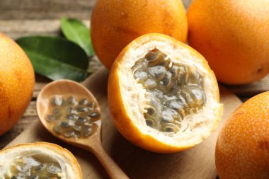 Olgun tutku meyveleri, tohumlar ve yeşil yapraklar masada, yakın plan.