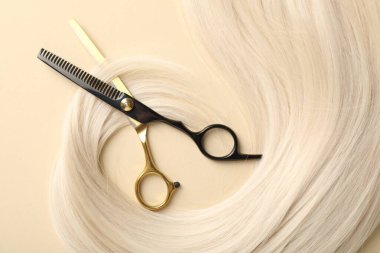 Bej arka planda saç kilidi ve makas, düz yatış