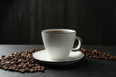 Kahve fincanda, fasulye siyah masada, yakın plan.