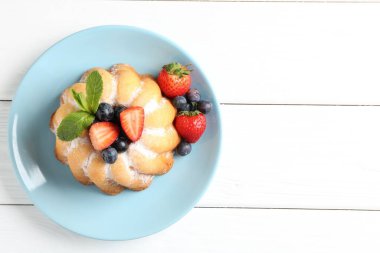 Beyaz ahşap masada pudra şekeri ve böğürtlenli Lezzetli kek, üst manzara. Metin için boşluk