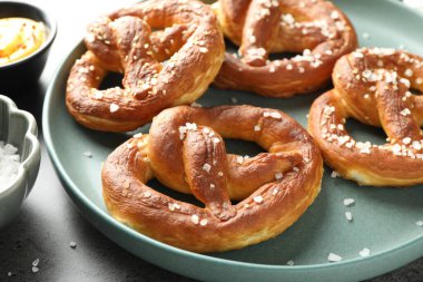 Gri masadaki tuzlu ve soslu krakerler, yakın plan.