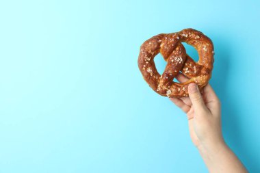 Açık mavi arka planda lezzetli krakerli kadın, yakın plan. Metin için boşluk