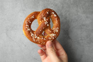 Gri desenli duvarın yanında lezzetli krakerli kadın, yakın plan.