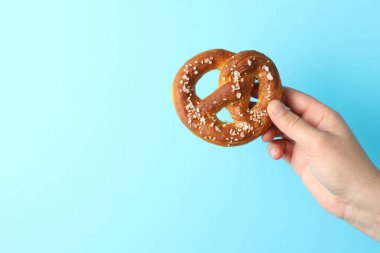 Açık mavi arka planda lezzetli krakerli kadın, yakın plan. Metin için boşluk