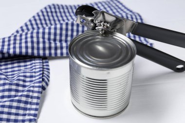 Konserve açacağı ve teneke kutu beyaz ahşap masada, yakın plan.