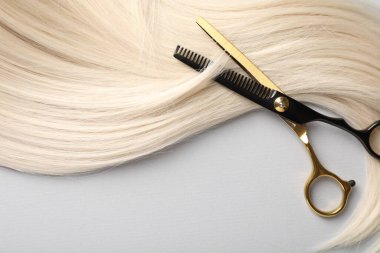 Sarı saç tokası ve makas açık gri arka plan, üst görünüm