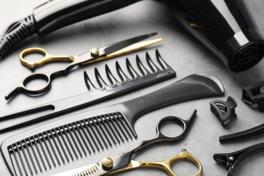 Gri masadaki farklı kuaför aletleri, yakın plan.