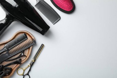 Beyaz arka planda farklı kuaför aletleri, düz yatış. Metin için boşluk