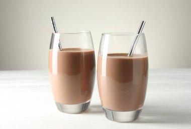 Lezzetli çikolatalı süt bardakta beyaz tahta masada, yakın plan.