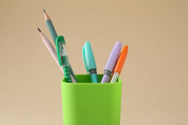 Kalemler ve kalemler bej arka planda, yakın plan