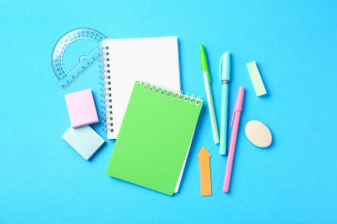 Açık mavi zemin üzerinde kalemler ve diğer kırtasiye düz yatıyordu