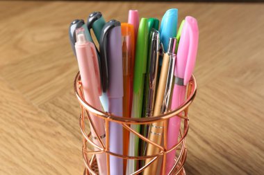 Ahşap masanın üzerinde bir sürü farklı kalem var, yakın plan.