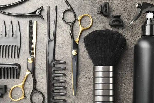 Gri masada farklı kuaförlerin aletleri var.