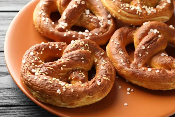 Koyu ahşap masada tuzlu krakerler, yakın plan.