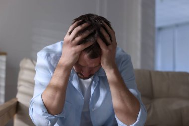 Evdeki kanepede depresif bir adam. Zihinsel sağlık sorunu