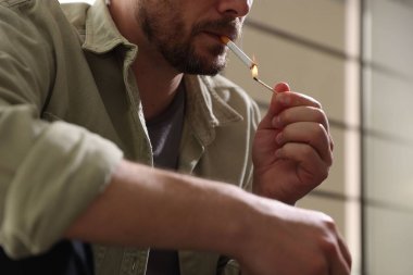 Arka planda kibrit yakan adam, yakın plan.