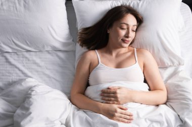 Evdeki yatakta uyuyan güzel bir kadın.