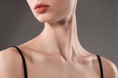 Gri arka planda mükemmel bir teni olan kadın, yakın plan.