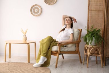 Evdeki rahat koltukta dinlenen güzel kadın.