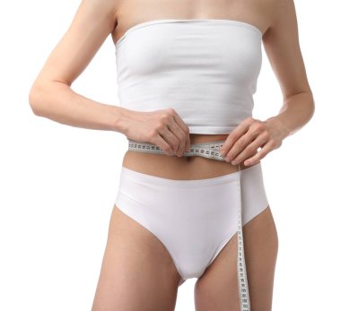 İnce vücutlu ve beyaz arka planda mezurası olan kadın, yakın plan.