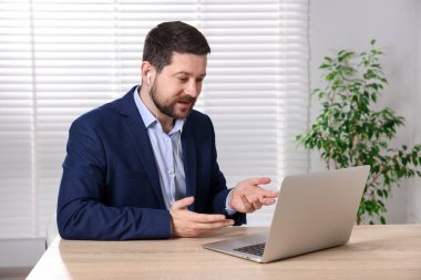 İçerideki masada dizüstü bilgisayarı olan internet hoparlörü.