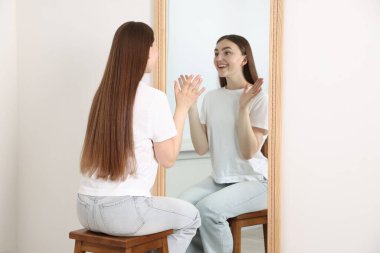 Güzel bir kadın aynada kendine bakıyor.