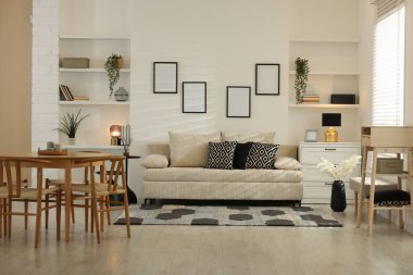 Rahat bir kanepe, masa, sandalyeler ve içeride şifonyer. İç tasarım