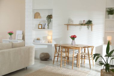 Odada rahat bir kanepe ve sandalyeli şık bir yemek masası. İç tasarım