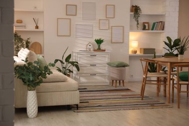 Odada rahat bir kanepe ve sandalyeli şık bir yemek masası. İç tasarım