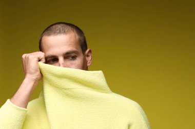 Zeytin arka planında şık giyinmiş yakışıklı bir adamın modaya uygun portresi.