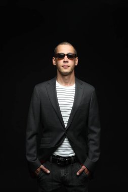 Siyah arka planda şık giyinmiş yakışıklı bir adamın şık portresi.