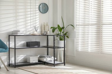 Beyaz duvarın yanında farklı dekorları olan konsol masası. İç tasarım