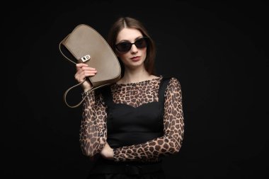 Siyah arka planda şık giyinmiş güzel bir kadının moda portresi.