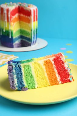 Açık mavi masadaki lezzetli gökkuşağı pastası, yakın plan.