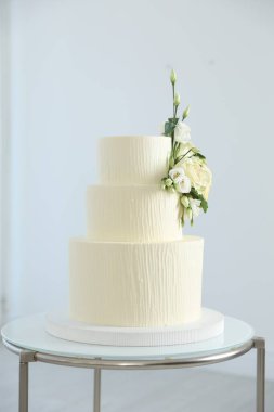 İçerideki masada çiçeklerle süslenmiş nefis düğün pastası.